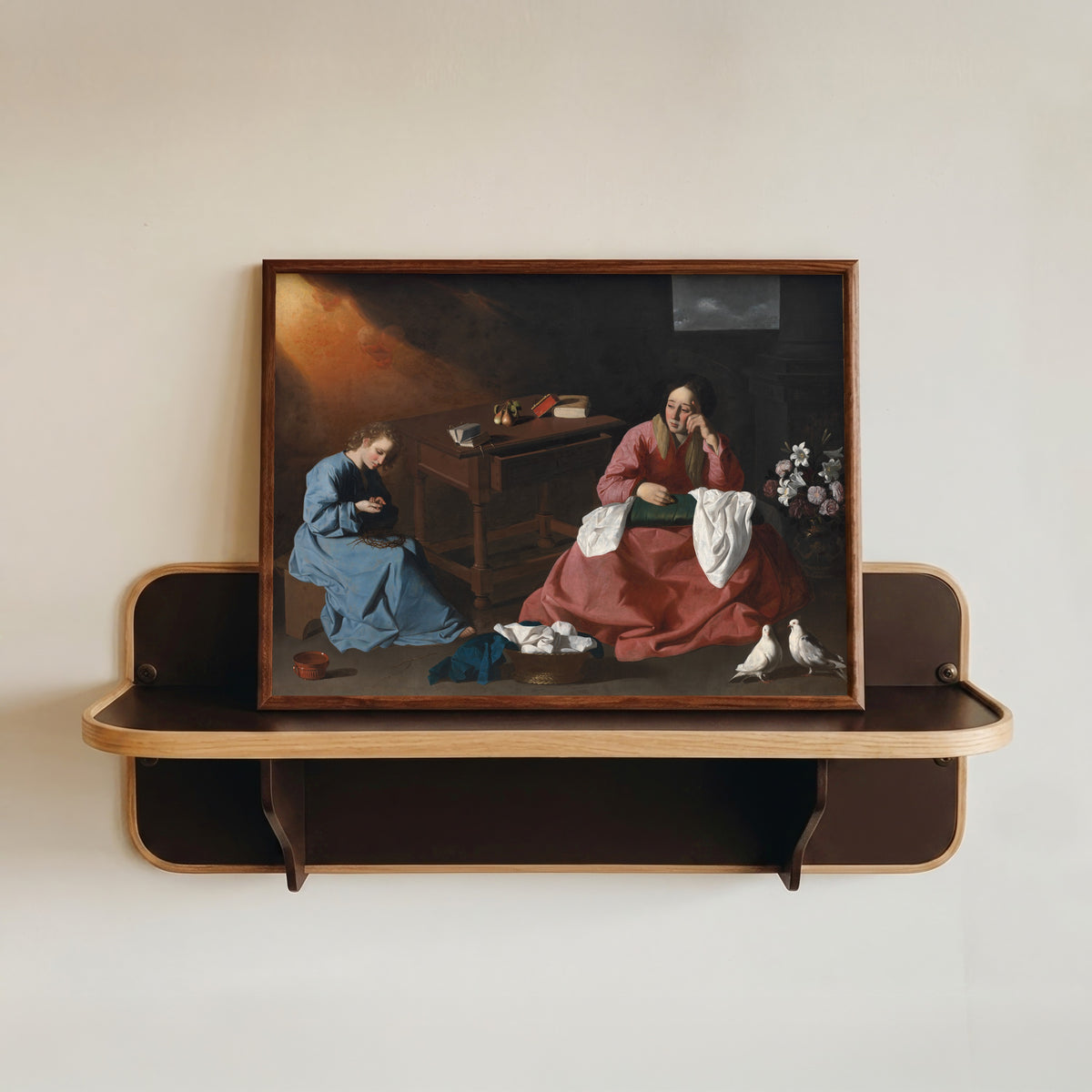 Framed art print of Christ and the Virgin in the House at Nazareth by Francisco de Zurbarán, in a dark wood frame resting on a wall shelf