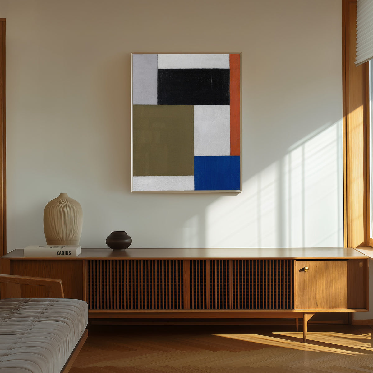 Framed art print of Composition by Theo van Doesburg, in a thin light frame on a sunlit wall above a wooden sideboard