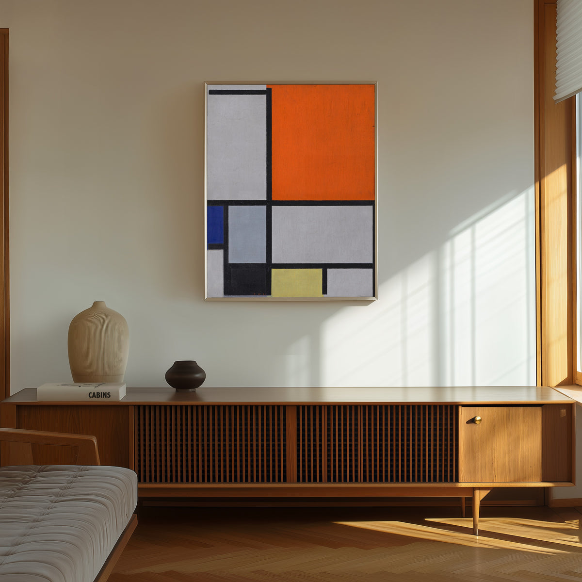 Framed art print of Composition with Large Red Plane, Blue, Gray, Black and… by Piet Mondrian, in a thin light frame on a sunlit wall above a wooden sideboard