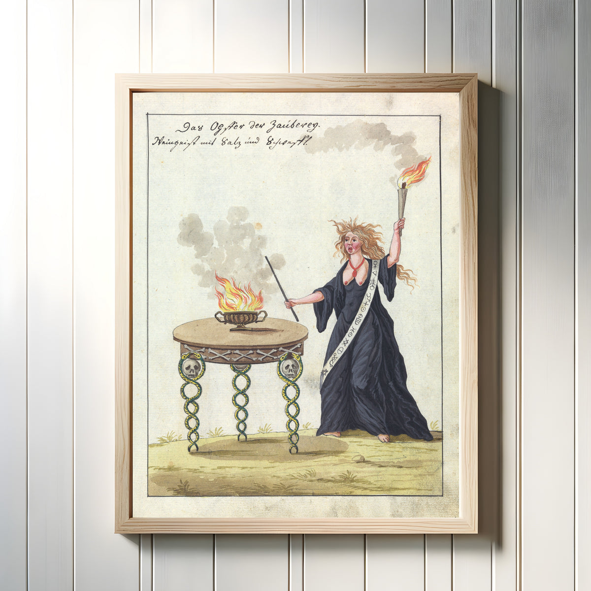 Framed art print of Das Opfer der Zauberey by Unknown artist, in a light wood frame on a white panelled wall