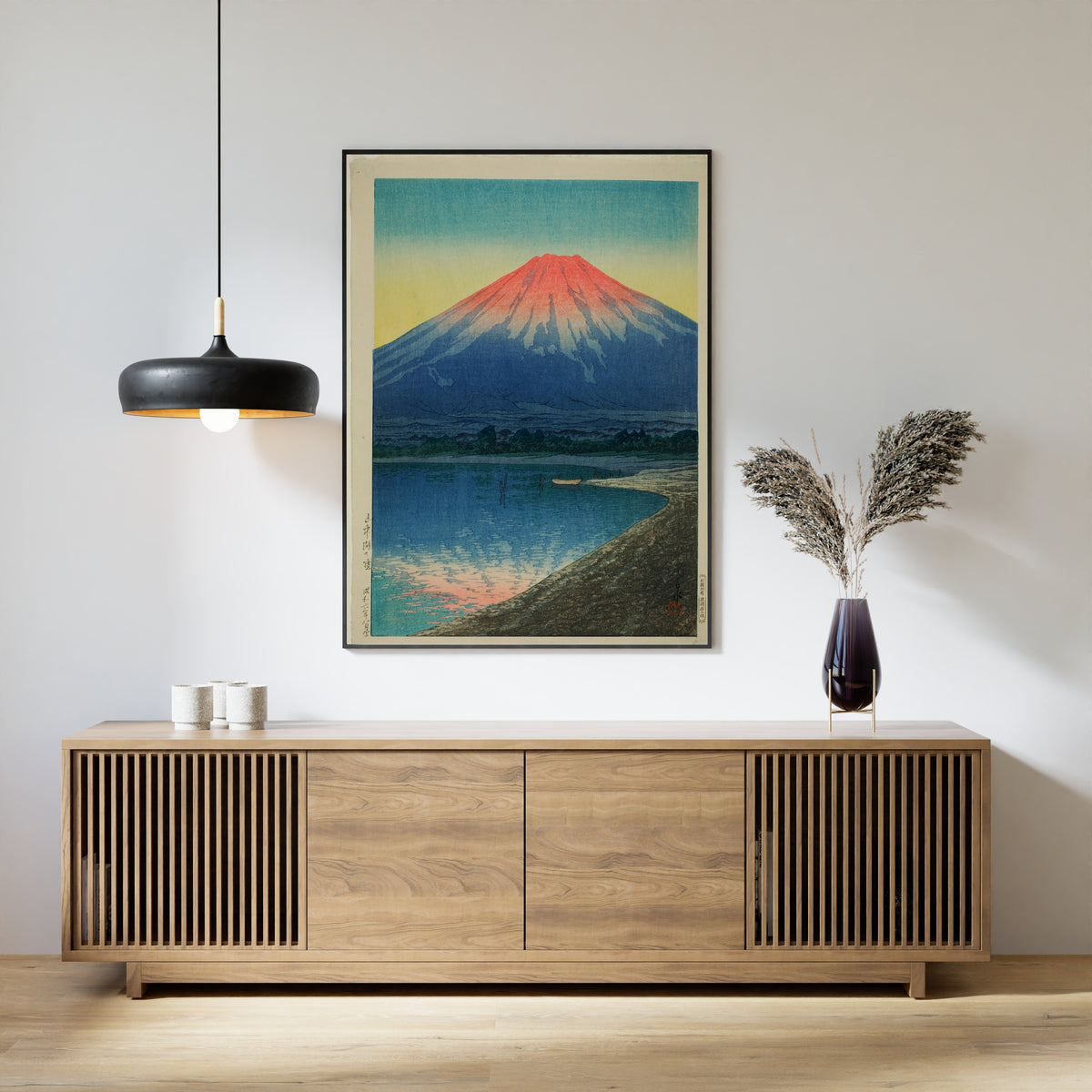 Framed art print of Daybreak over Lake Yamanaka by Kawase Hasui, above a slatted wood sideboard
