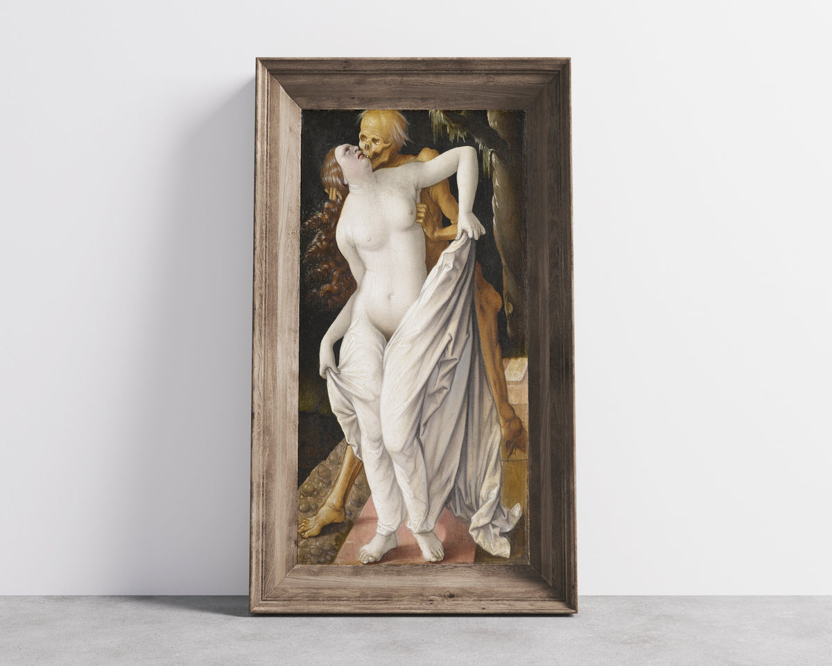 Framed art print of Death and the Maiden by Hans Baldung Grien, in a wide wooden frame leaning against a concrete wall