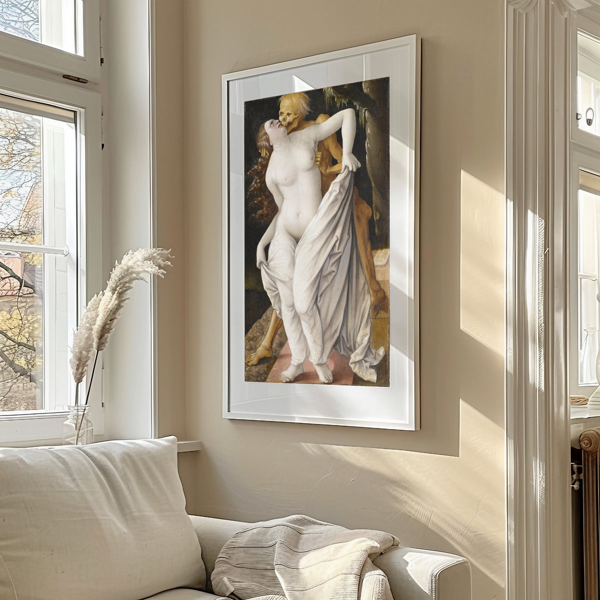 Framed art print of Death and the Maiden by Hans Baldung Grien, in a sunlit living room above a sofa