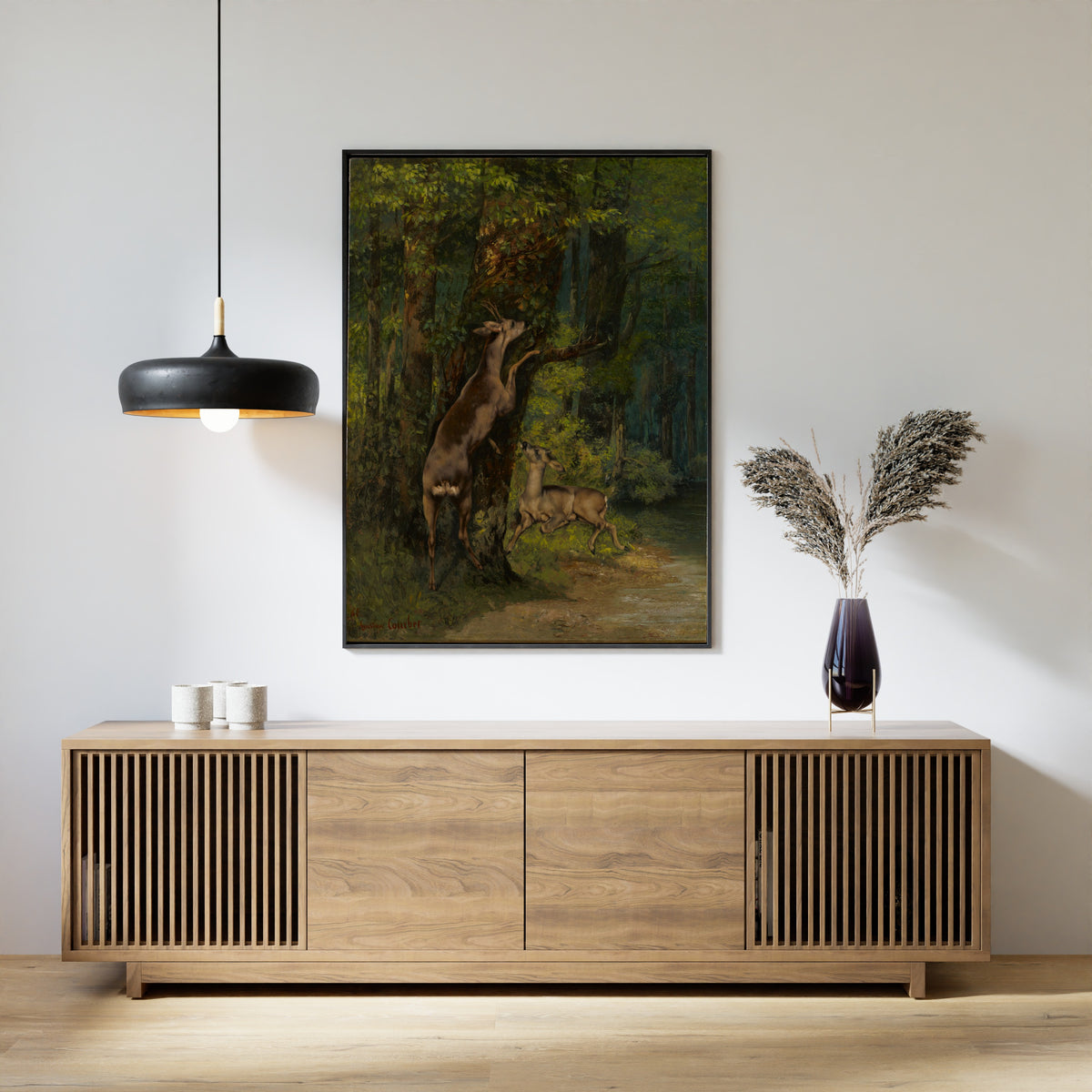 Deer in the Forest by Gustave Courbet — framed above a slatted wood sideboard