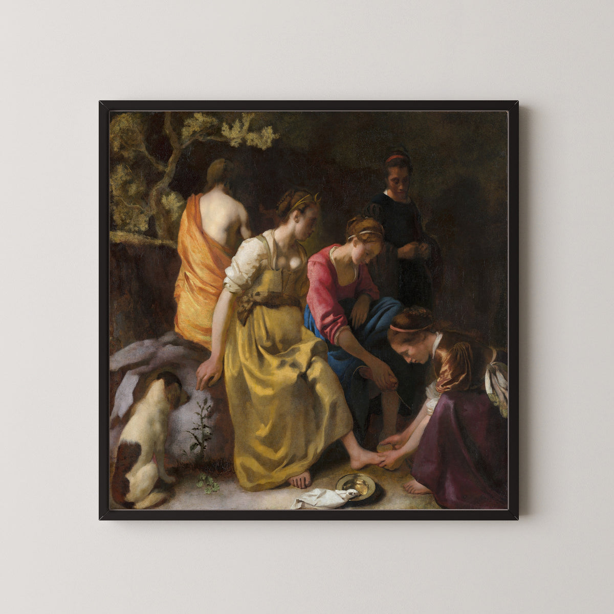 Framed art print of Diana and Her Nymphs by Johannes Vermeer, in a black frame on a pale wall