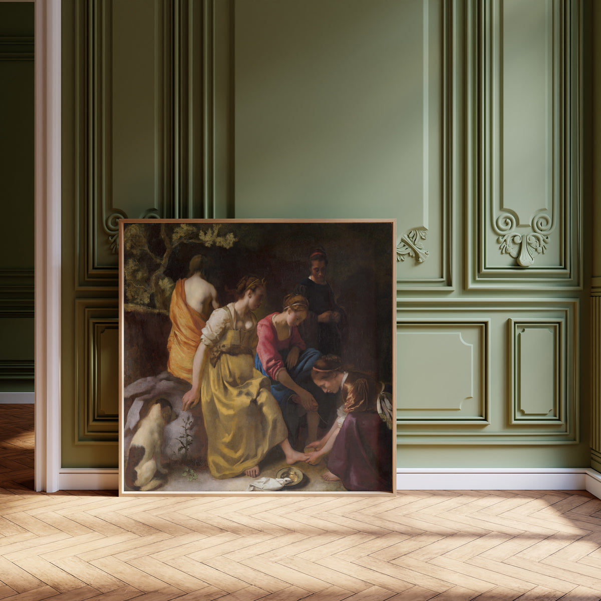 Framed art print of Diana and Her Nymphs by Johannes Vermeer, leaning against olive-green panelling on a herringbone floor