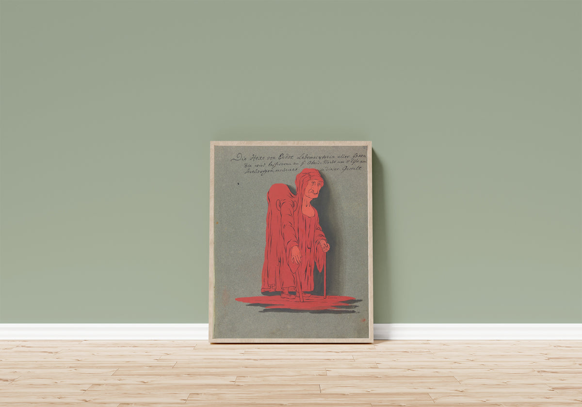 Framed art print of Die Hexe von Endor, Lehrmeisterin aller Hexen by Unknown artist, in a light wood frame leaning on a sage green wall above a wooden floor
