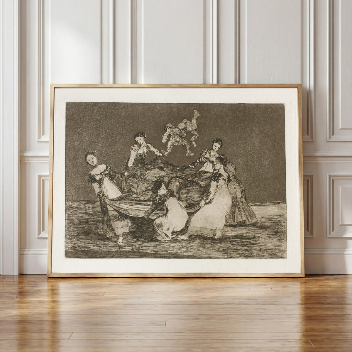Framed art print of Disparate femenino (Feminine Folly), from Los Disparates by Francisco de Goya, in a light wood frame leaning against a panelled white wall
