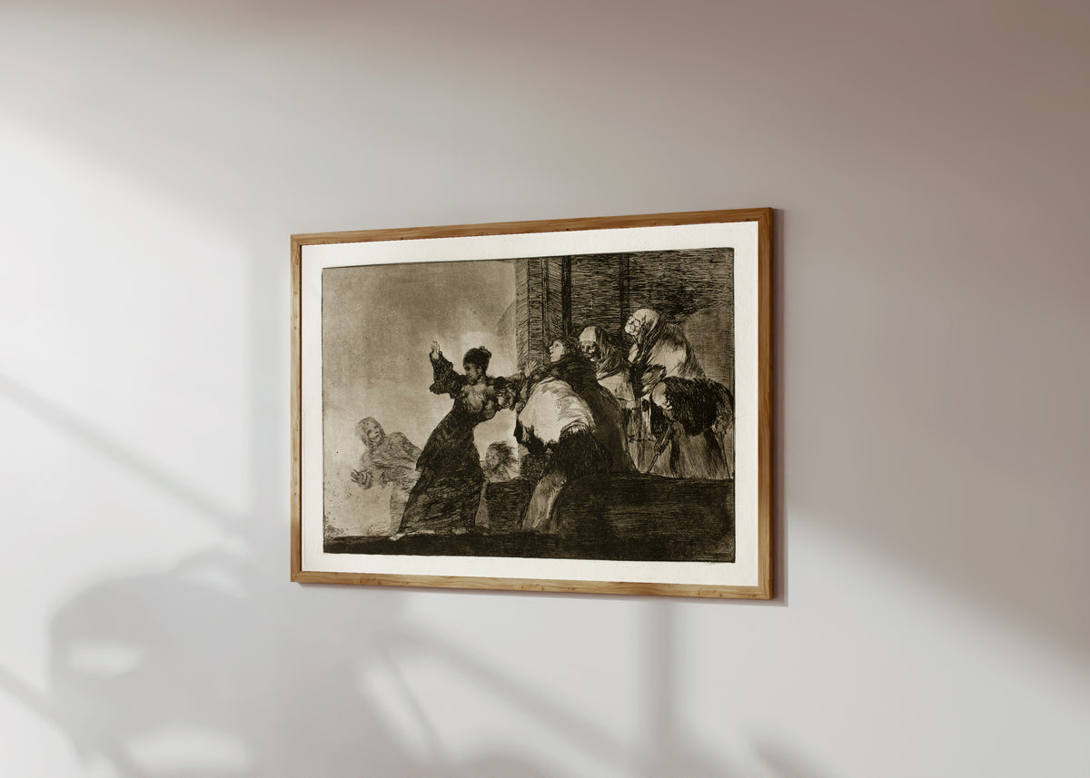 Framed art print of Disparate pobre (Poor Folly), from Los Disparates by Francisco de Goya, in a light wood frame on a sunlit white wall, seen at a slight angle