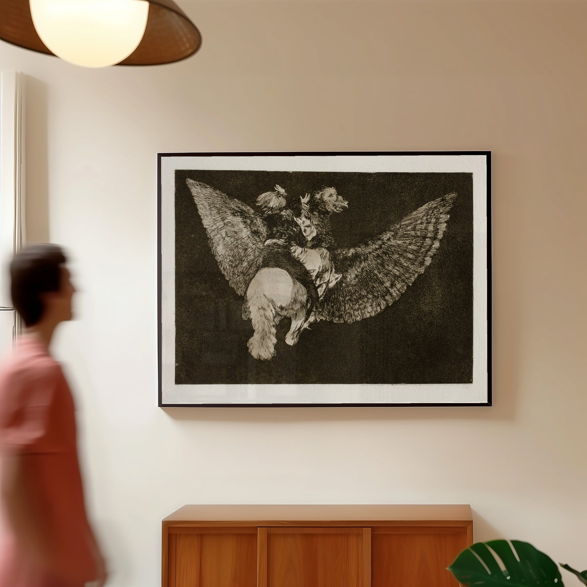 Framed art print of Disparate volante (Flying Folly), from Los Disparates by Francisco de Goya, in a slim black frame on a warm wall in a sunlit room