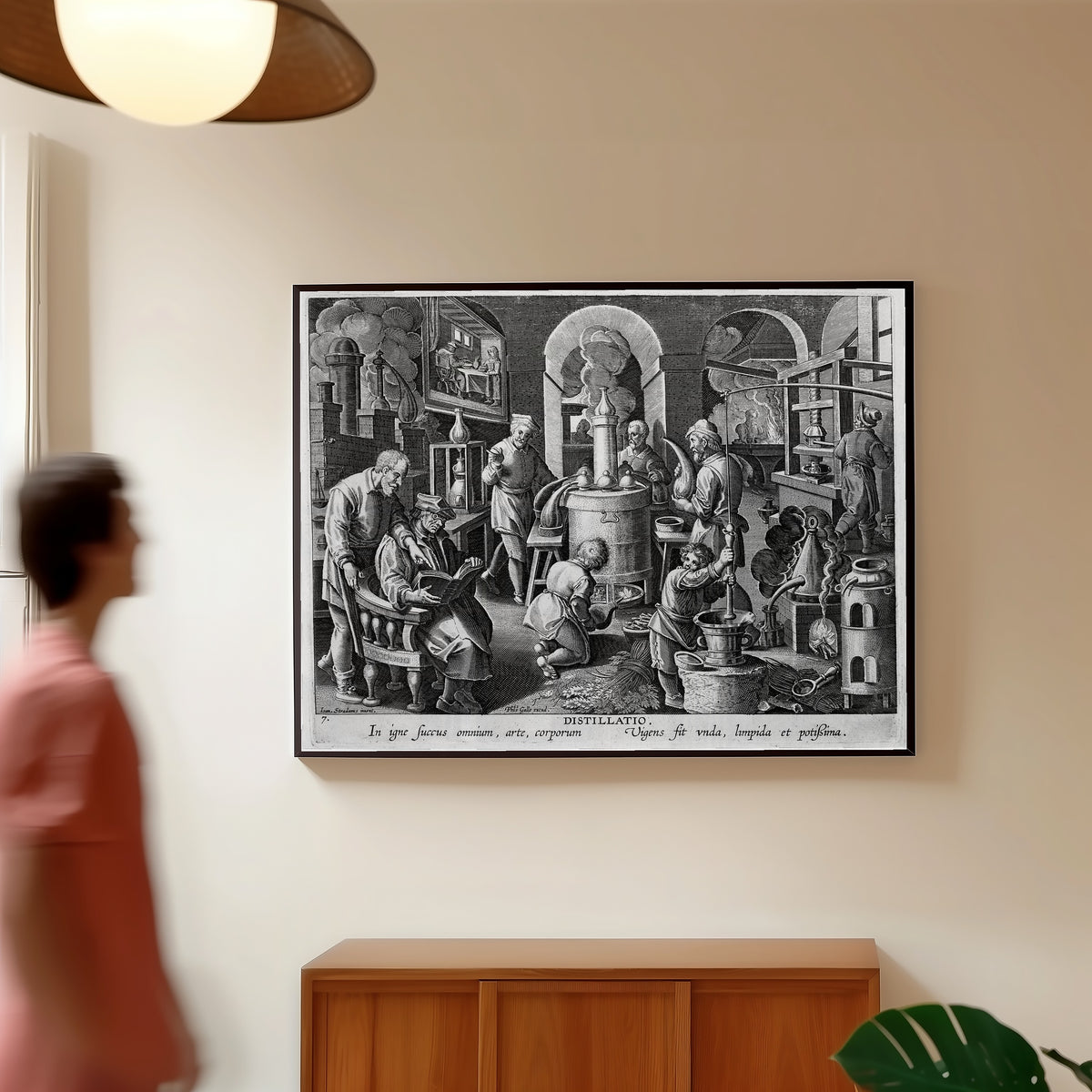 Framed art print of Distillatio: the Alchemist's Laboratory… by Philips Galle after Jan van der Straet, in a slim black frame on a warm wall in a sunlit room