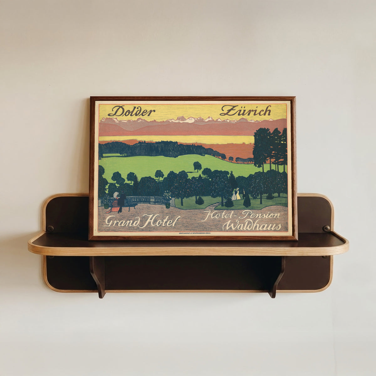 Framed art print of Dolder Grand Hotel, Hotel-Pension Waldhaus, Zürich by Emil Cardinaux, in a dark wood frame resting on a wall shelf