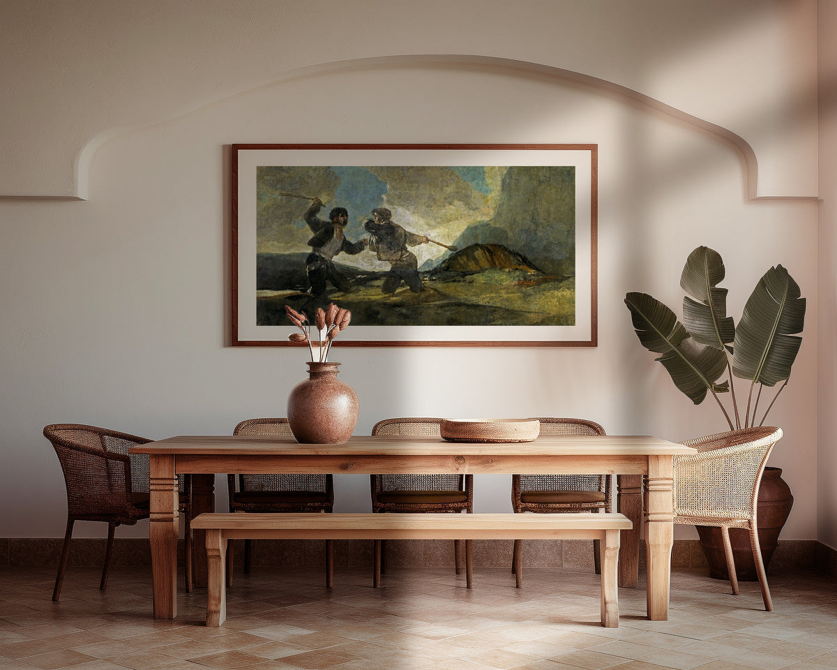 Framed art print of Duelo a garrotazos (Fight with Cudgels) by Francisco de Goya, above a wooden dining table