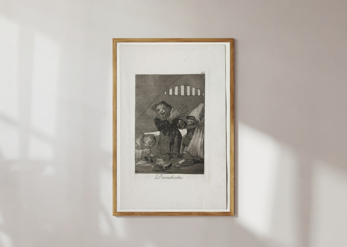 Framed art print of Duendecitos (Hobgoblins), Los Caprichos, Plate 49 by Francisco de Goya, in a light wood frame on a sunlit white wall