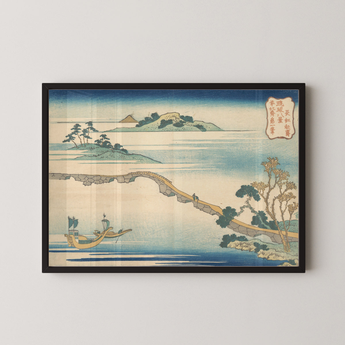 Framed art print of Eight Views of the Ryūkyū Islands: Autumn Sky at Chōkō by Katsushika Hokusai, in a black frame on a pale wall