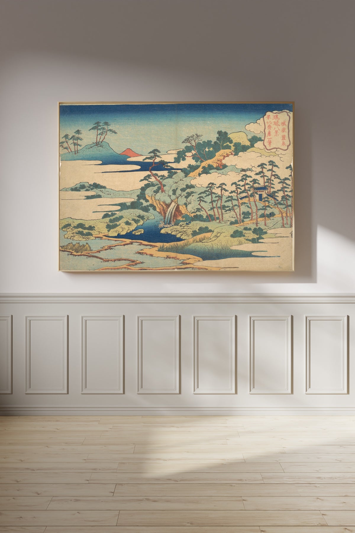 Framed art print of Eight Views of the Ryūkyū Islands: The Sacred Spring at Jōgaku by Katsushika Hokusai, on a panelled wall in afternoon light