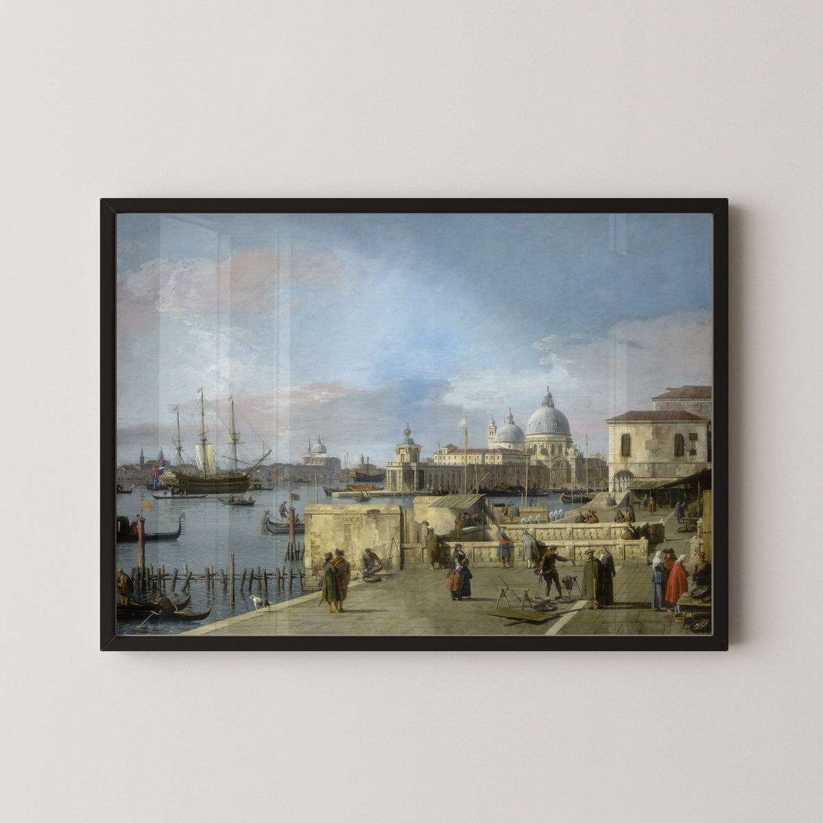 Framed art print of Entrance to the Grand Canal from the Molo, Venice by Canaletto, in a black frame on a pale wall