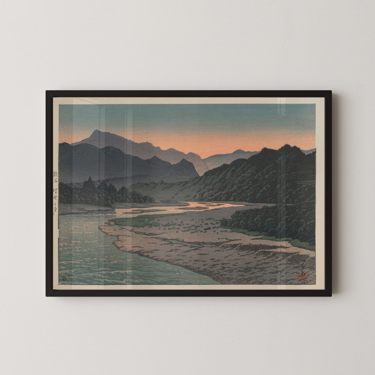 Framed art print of Evening at Minano, Chichibu by Kawase Hasui, in a black frame on a pale wall