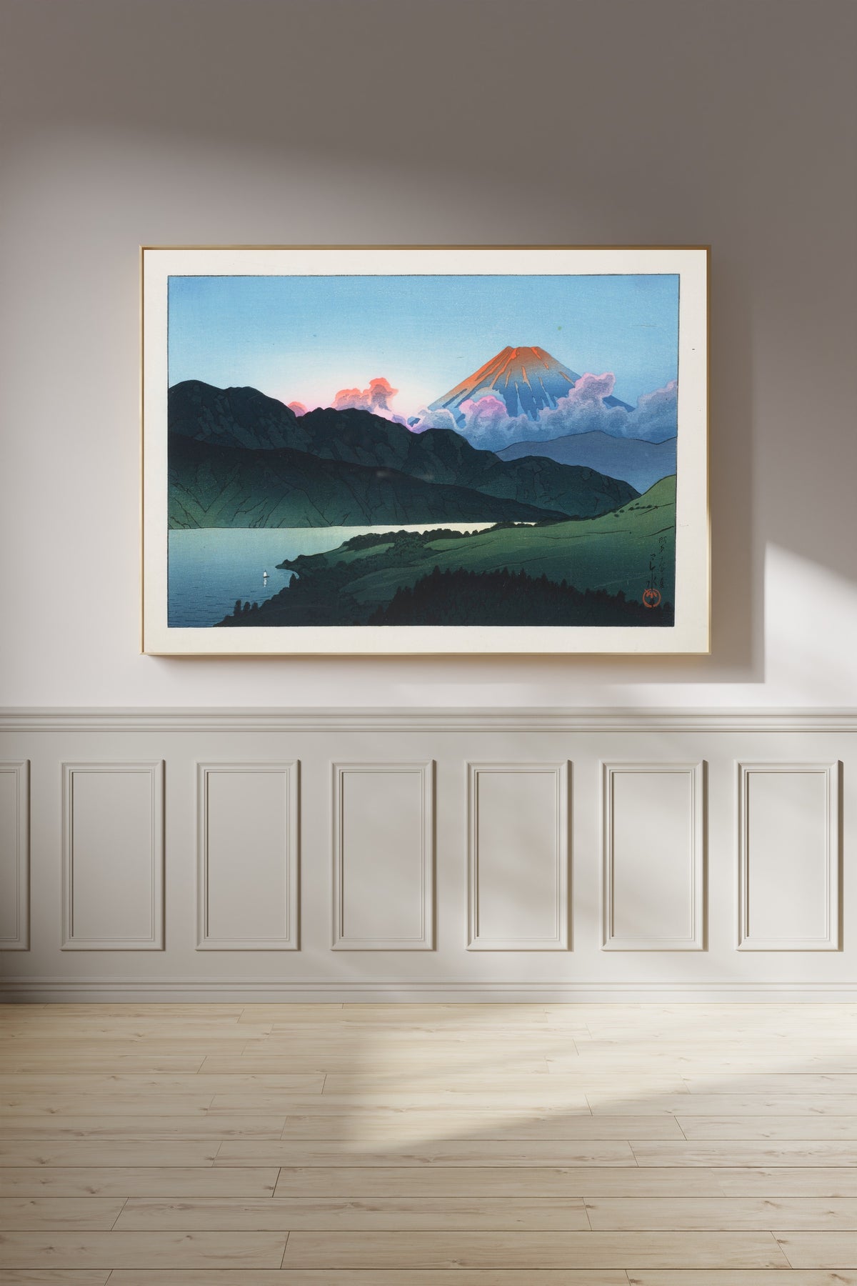 Framed art print of Evening of Mount Fuji from Lake Ashino-ko by Kawase Hasui, on a panelled wall in afternoon light