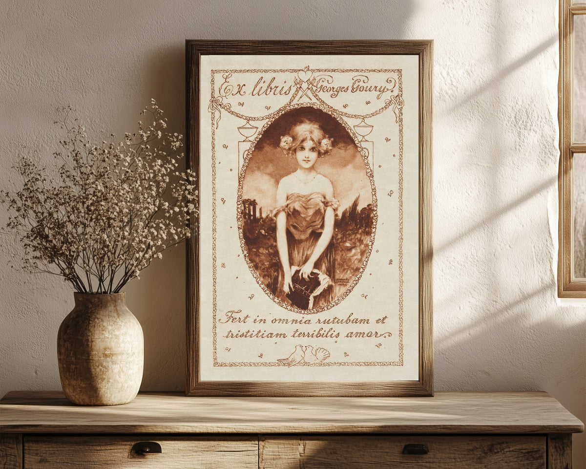 Framed art print of Ex Libris Georges Goury by Raphael Kirchner, in a dark wood frame leaning on a rustic console beside dried flowers