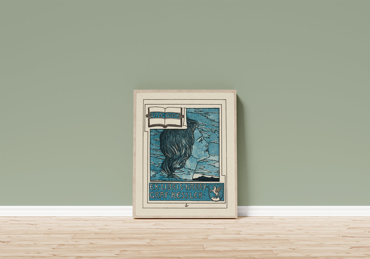 Framed art print of Ex Libris Harry Graf Kessler by Joseph Sattler, in a light wood frame leaning on a sage green wall above a wooden floor