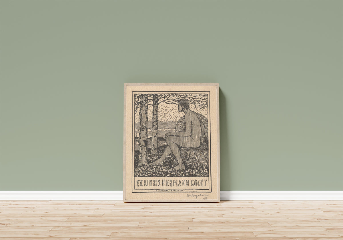 Framed art print of Ex Libris Hermann Gocht by Heinrich Vogeler, in a light wood frame leaning on a sage green wall above a wooden floor
