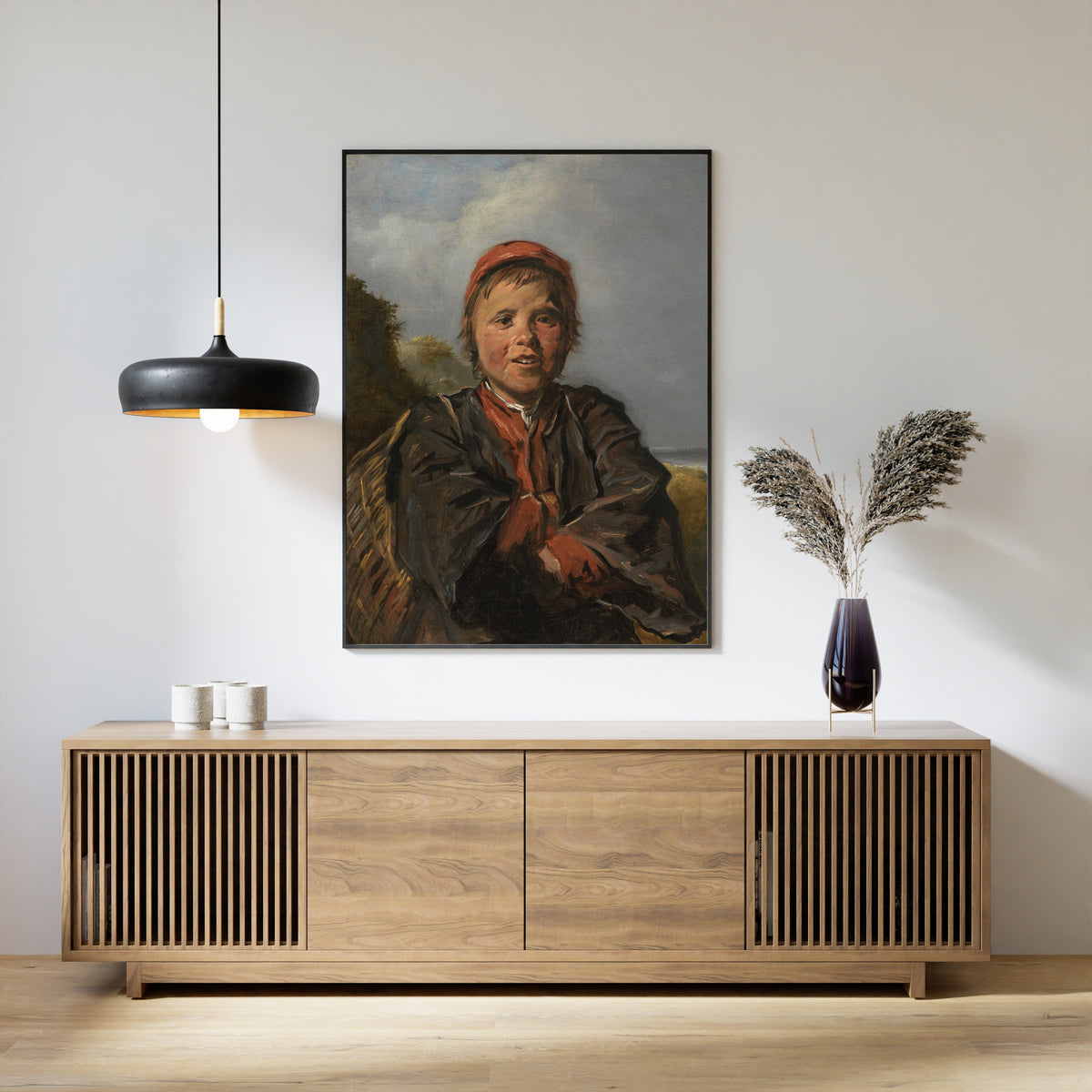 Framed art print of Fisherboy by Frans Hals, above a slatted wood sideboard