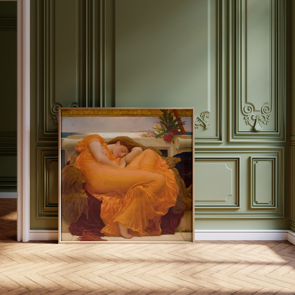 Framed art print of Flaming June by Frederic Leighton, leaning against olive-green panelling on a herringbone floor