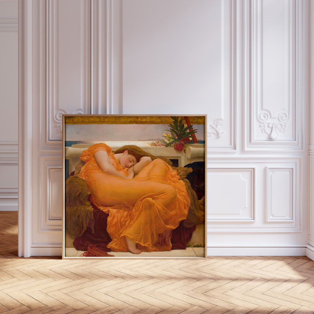 Framed art print of Flaming June by Frederic Leighton, leaning against pale pink panelling on a herringbone floor