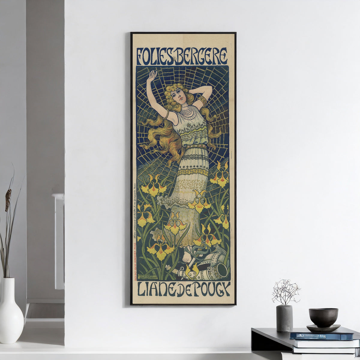 Framed art print of Folies Bergère: Liane de Pougy by Paul Berthon, on a white wall above books and a bowl
