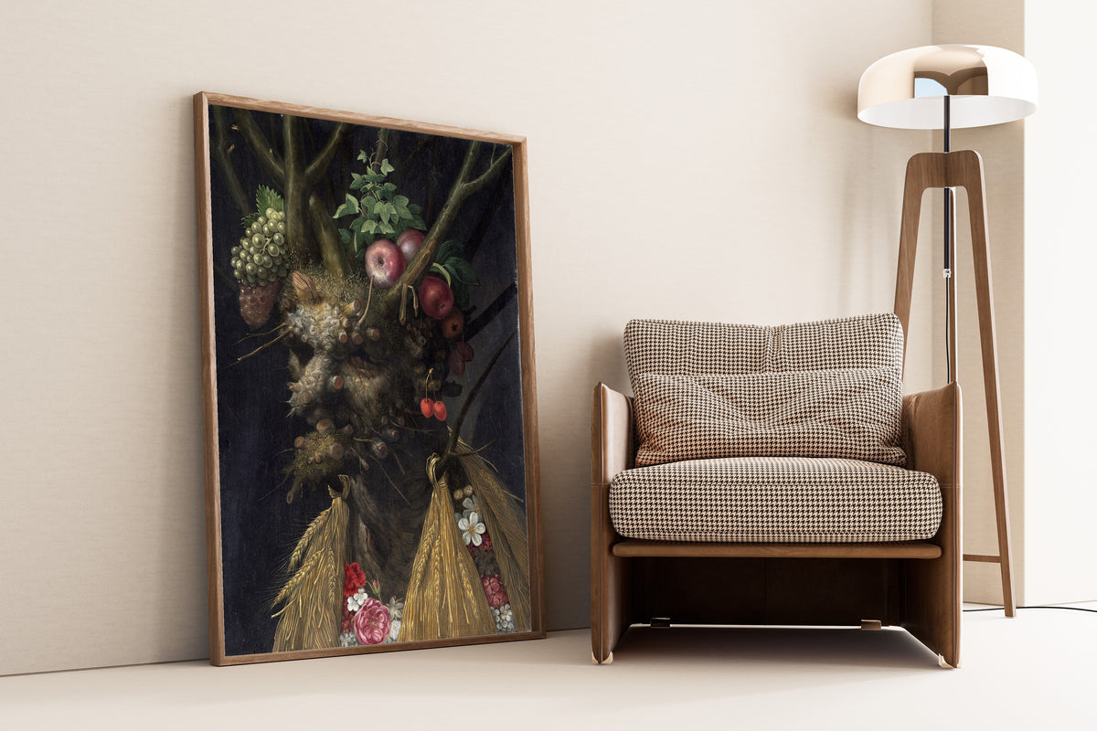 Framed art print of Four Seasons in One Head by Giuseppe Arcimboldo, leaning against a wall beside an armchair and a floor lamp