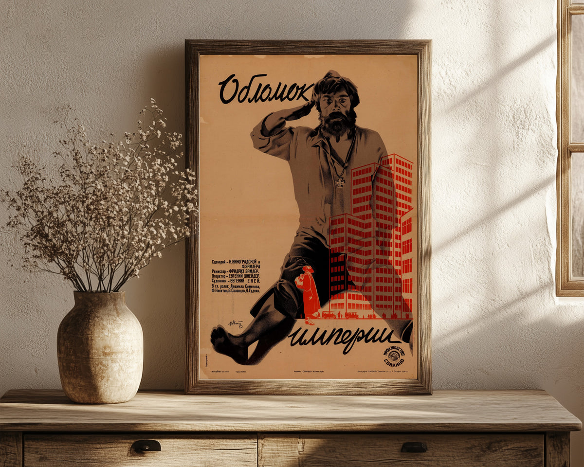 Framed art print of Fragment of an Empire by Mikhail Evstafiev, in a dark wood frame leaning on a rustic console beside dried flowers