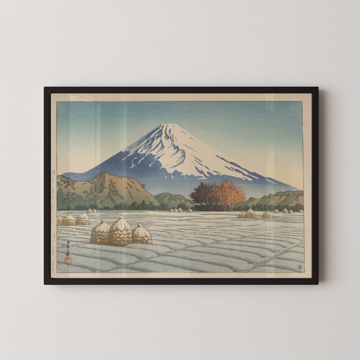 Framed art print of Frosty Morning in Nagaoka, Izu by Kawase Hasui, in a black frame on a pale wall