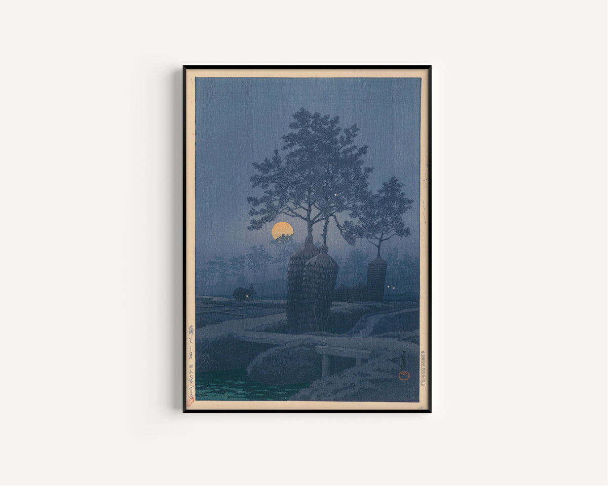 Framed art print of Full Moon at Gamo by Kawase Hasui, in a slim black frame on a plain white wall