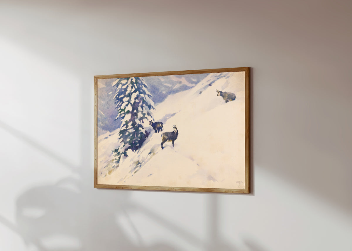 Framed art print of Gemsen im Schnee by Ludwig Hohlwein, in a light wood frame on a sunlit white wall, seen at a slight angle