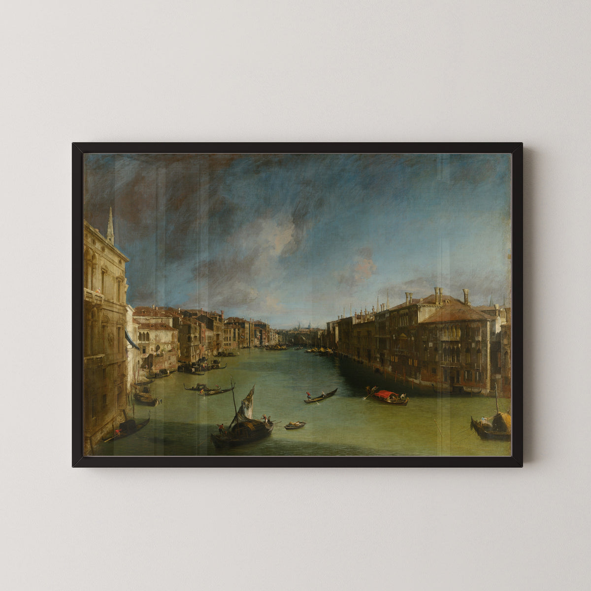 Framed art print of Grand Canal from Palazzo Balbi towards the Rialto by Canaletto, in a black frame on a pale wall