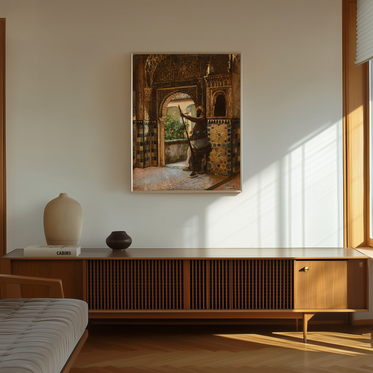 Framed art print of Guarding the Alhambra by Rudolf Ernst, in a thin light frame on a sunlit wall above a wooden sideboard