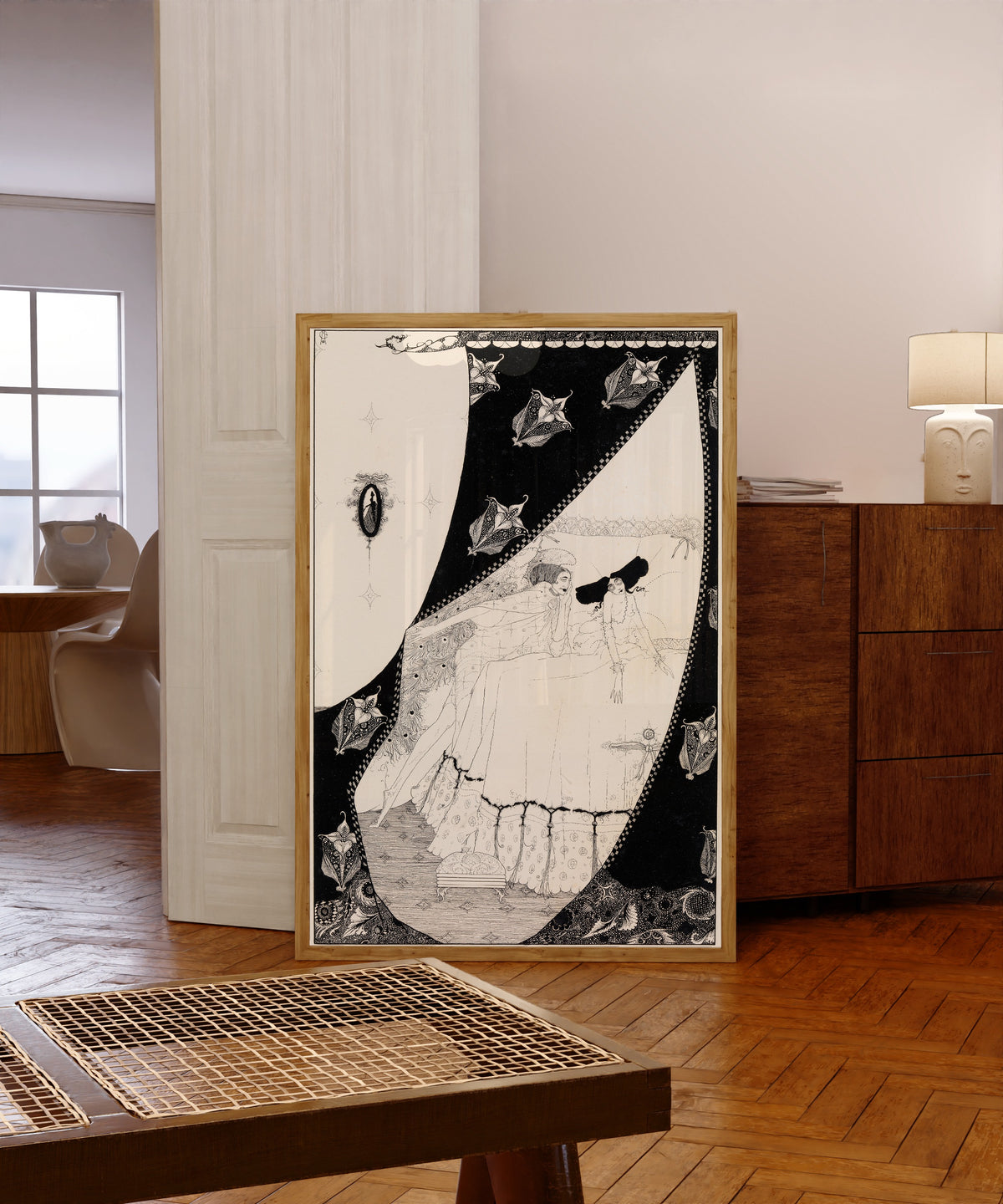 Framed art print of Her Guardian Sylph Prolonged the Happy Rest by Harry Clarke, in a light wood frame leaning in a warm room with a parquet floor