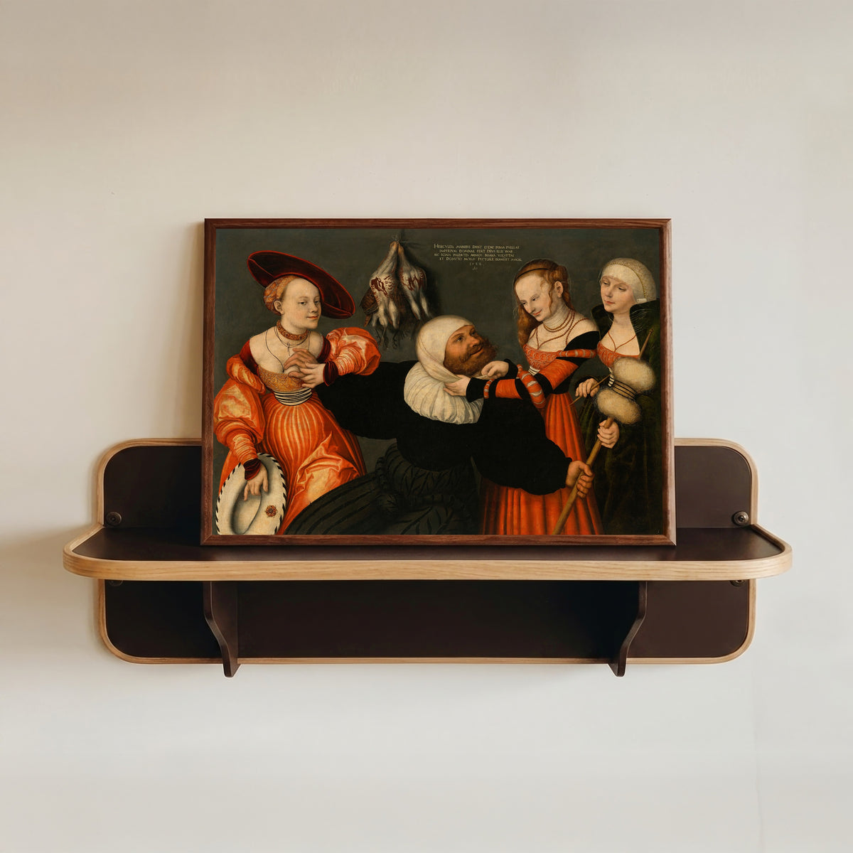 Framed art print of Hercules and Omphale by Lucas Cranach the Elder, in a dark wood frame resting on a wall shelf