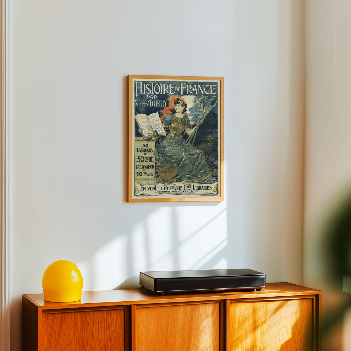 Framed art print of Histoire de France par Victor Duruy. 50 livraisons à 50… by Eugène Grasset, in a light wood frame on a white wall above an orange sideboard