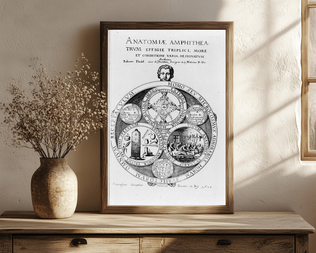 Framed art print of Homo seu Microcosmus: Title Plate of Anatomiae… by Robert Fludd, in a dark wood frame leaning on a rustic console beside dried flowers