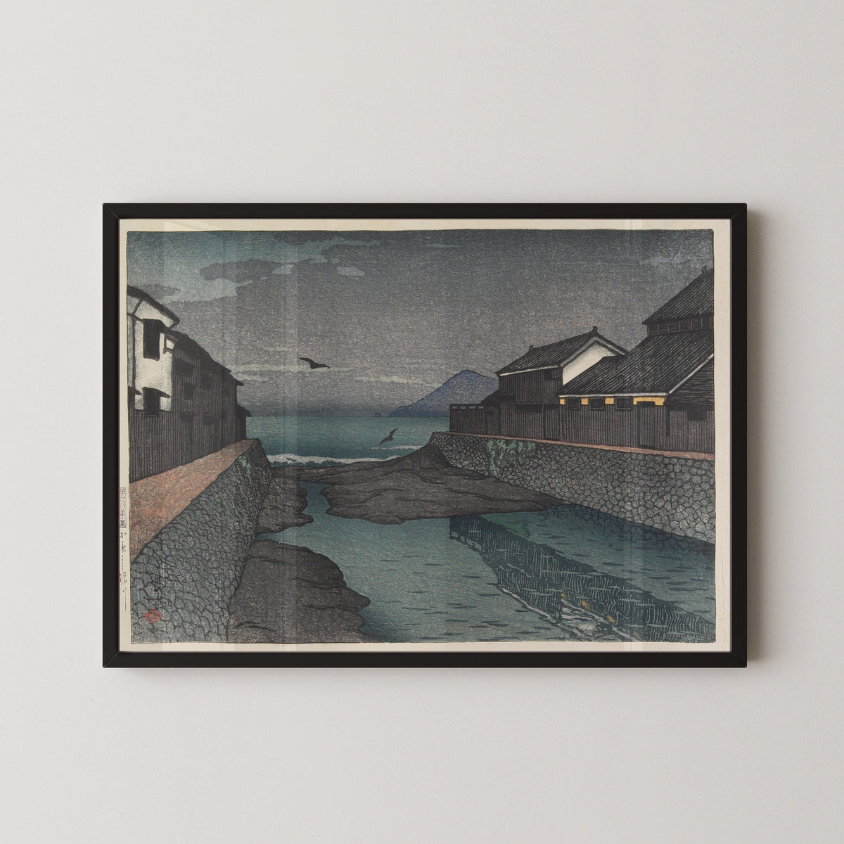 Framed art print of Hori River, Obama by Kawase Hasui, in a black frame on a pale wall