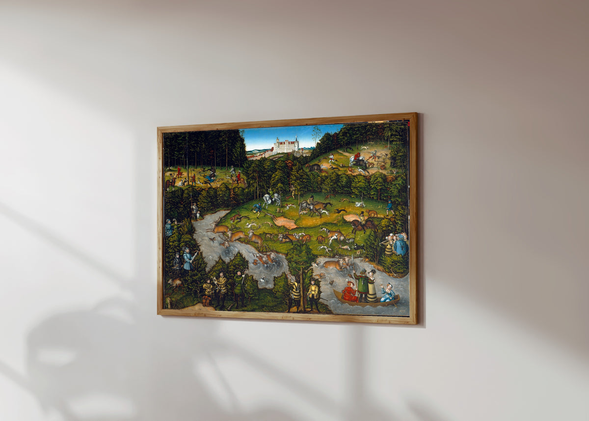 Framed art print of Hunting near Hartenfels Castle by Lucas Cranach the Elder, in a light wood frame on a sunlit white wall, seen at a slight angle