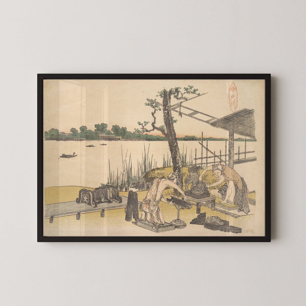 Framed art print of Imadogawa by Katsushika Hokusai, in a black frame on a pale wall