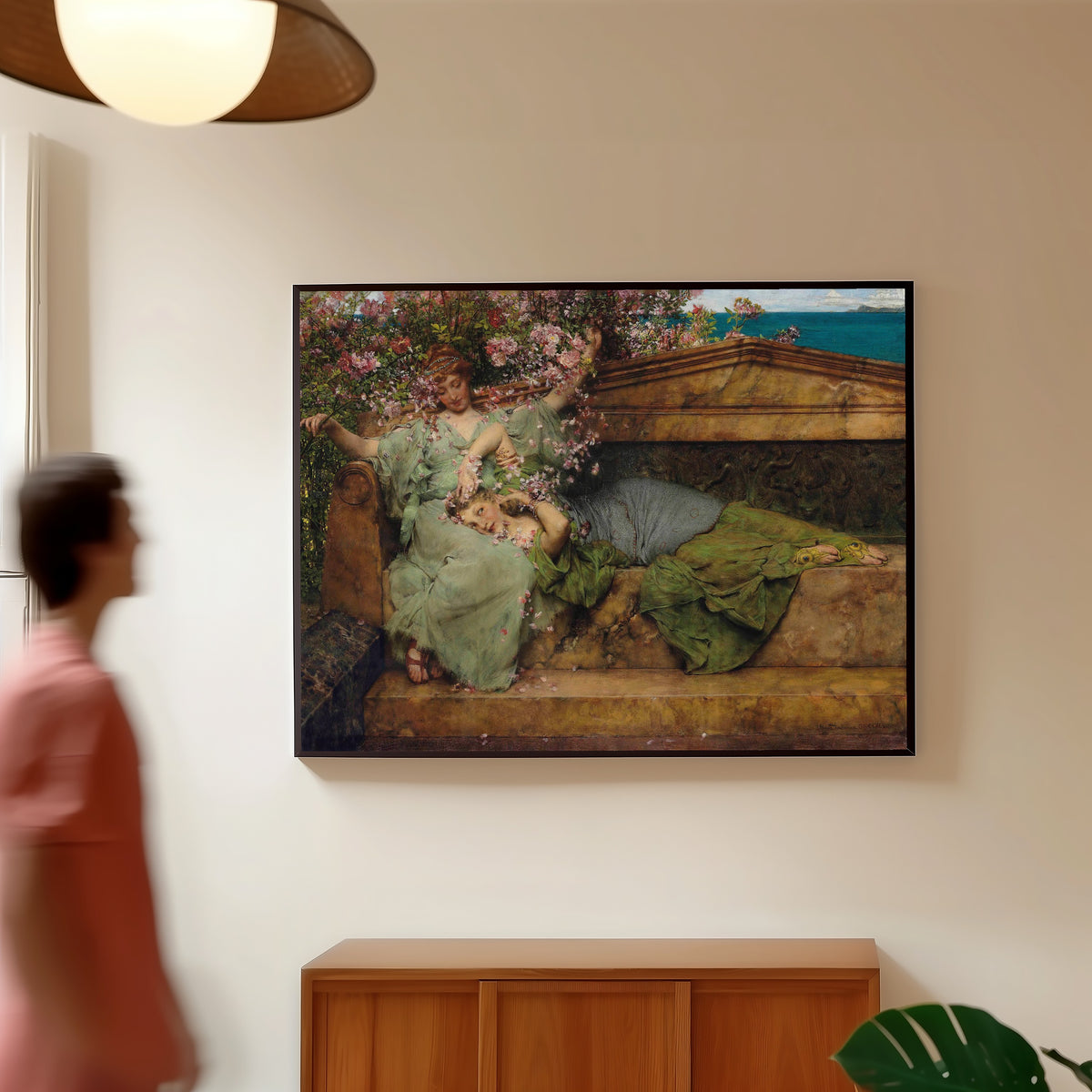 Framed art print of In a Rose Garden by Lawrence Alma-Tadema, in a slim black frame on a warm wall in a sunlit room