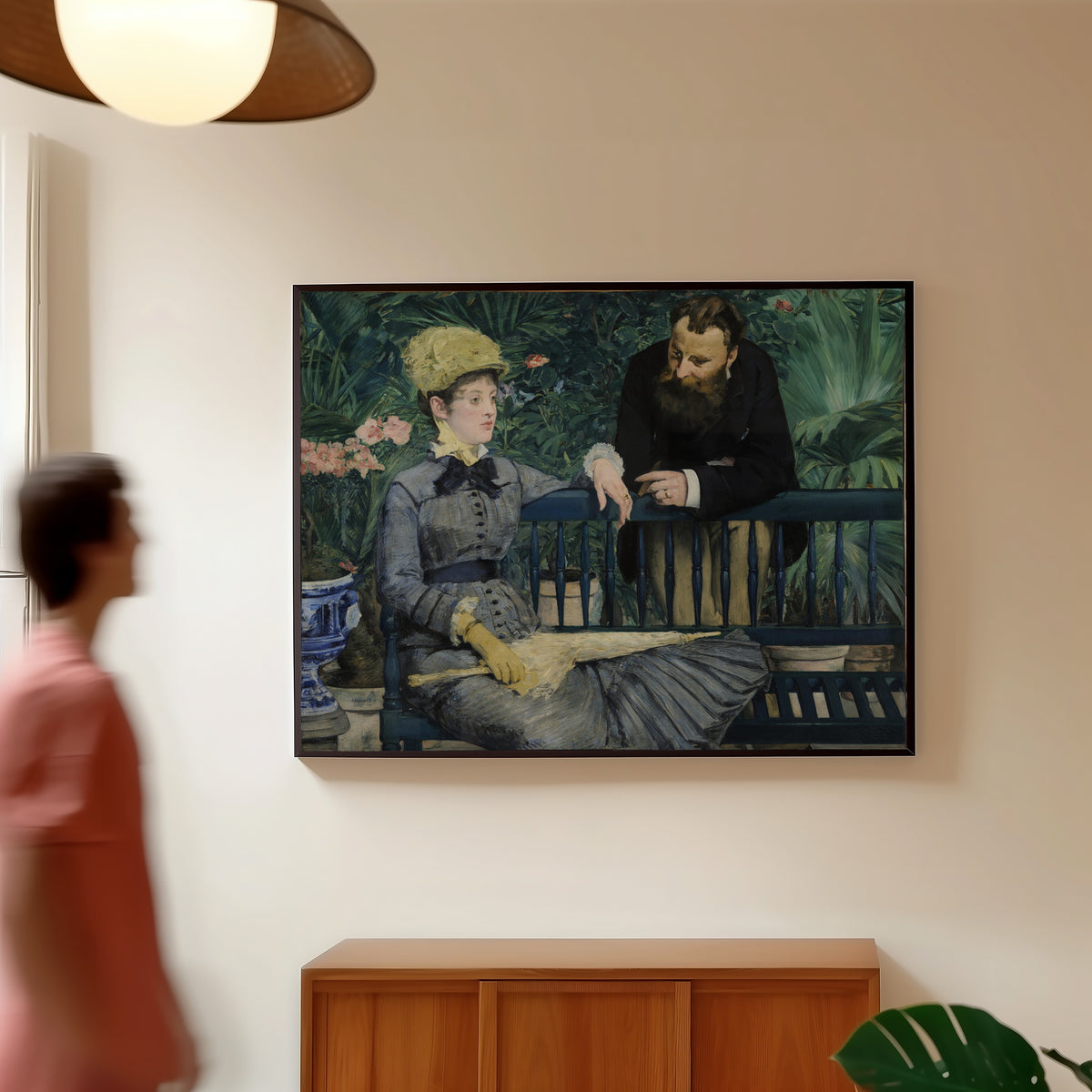 Framed art print of In the Conservatory by Édouard Manet, in a slim black frame on a warm wall in a sunlit room