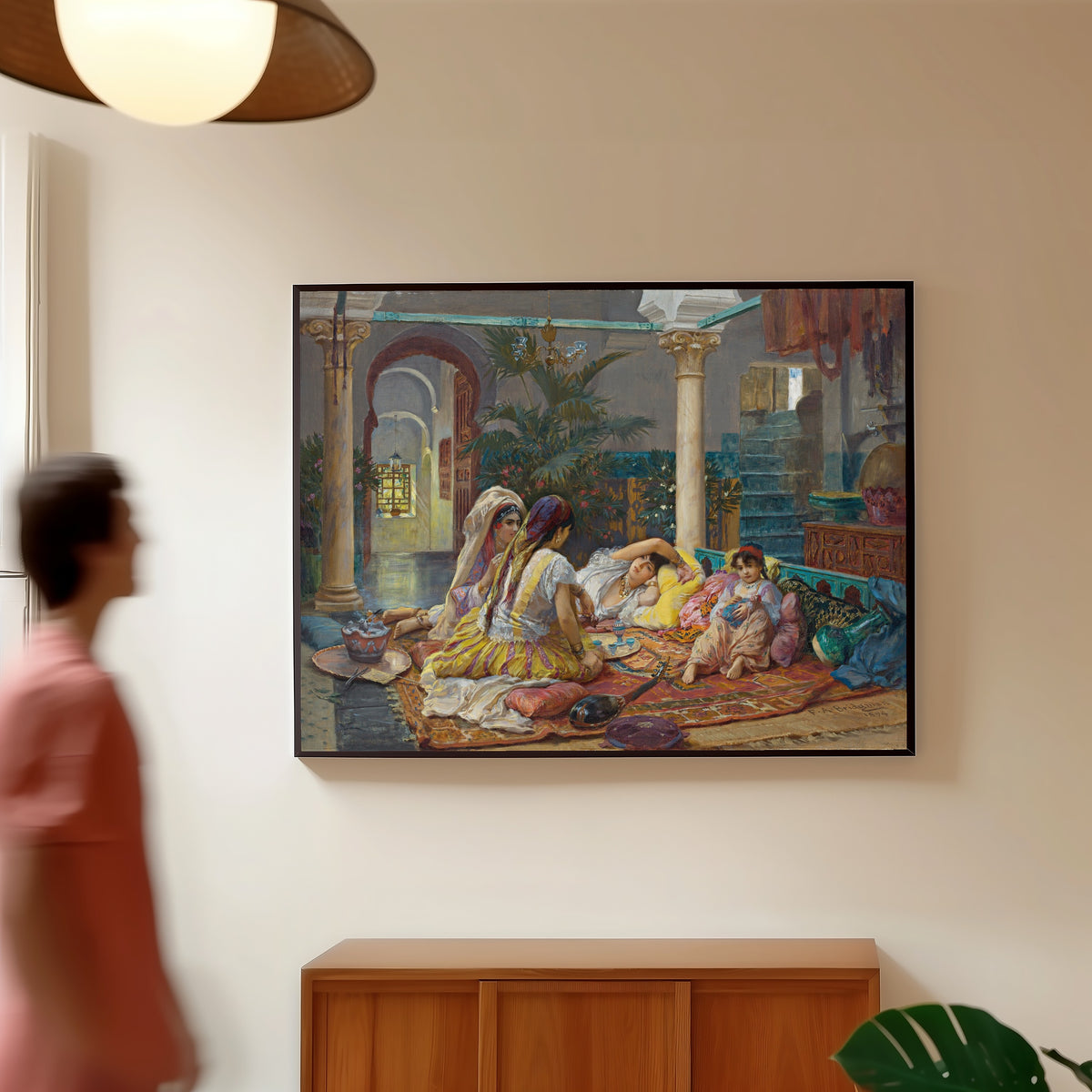 Framed art print of In the Harem by Frederick Arthur Bridgman, in a slim black frame on a warm wall in a sunlit room