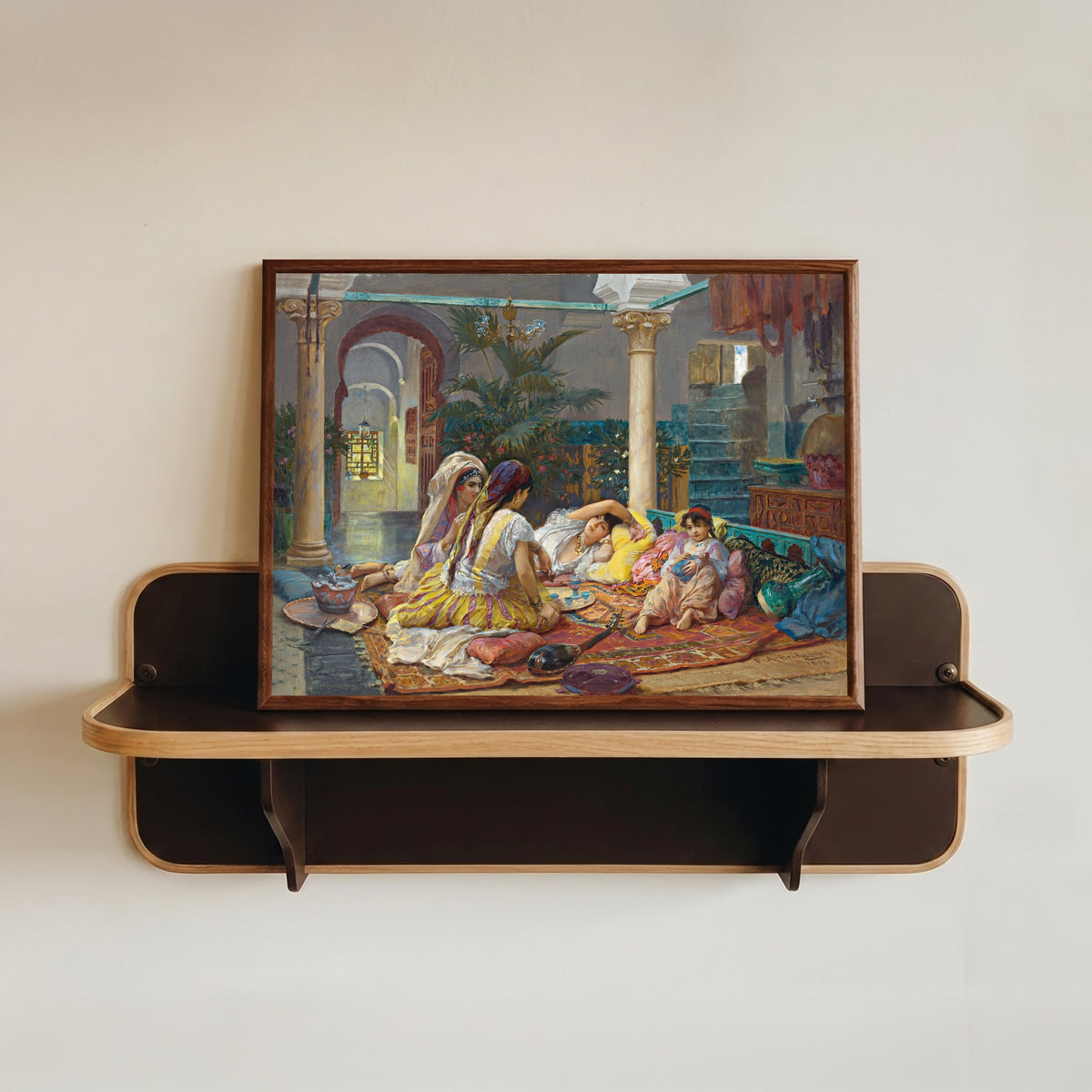 Framed art print of In the Harem by Frederick Arthur Bridgman, in a dark wood frame resting on a wall shelf