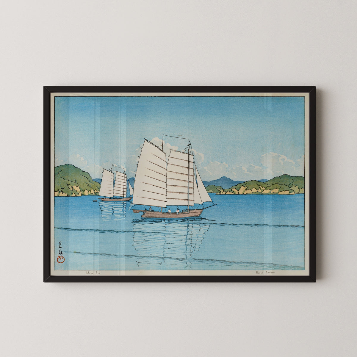 Framed art print of Inland Sea by Kawase Hasui, in a black frame on a pale wall