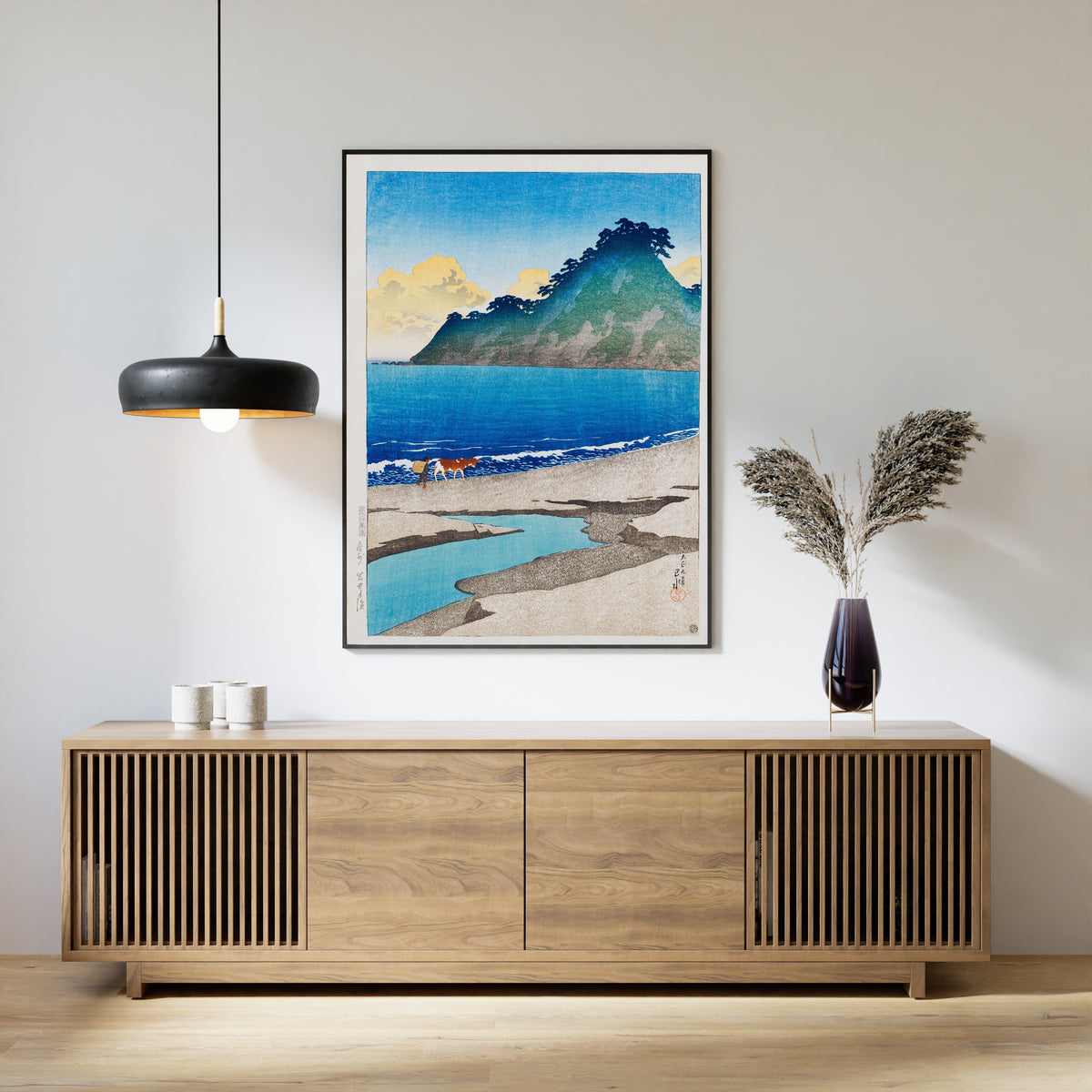 Framed art print of Iwai Beach, Awa Province by Kawase Hasui, above a slatted wood sideboard